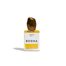 Bodha perfume bottle with gold cap and yellow liquid on white background