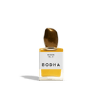 Bodha perfume bottle with gold cap and yellow liquid on white background